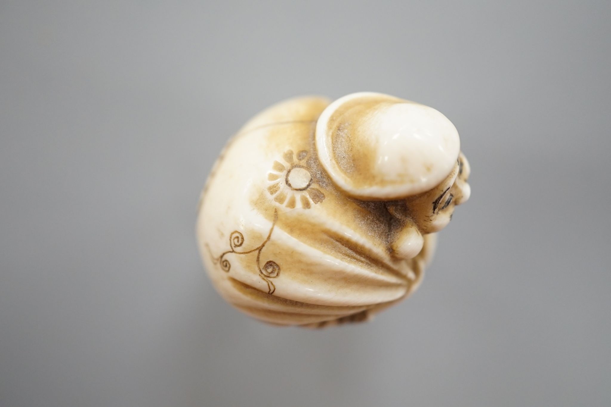 A Japanese ivory netsuke of Daikoku or Ebisu, Meiji period, 4 cms high.